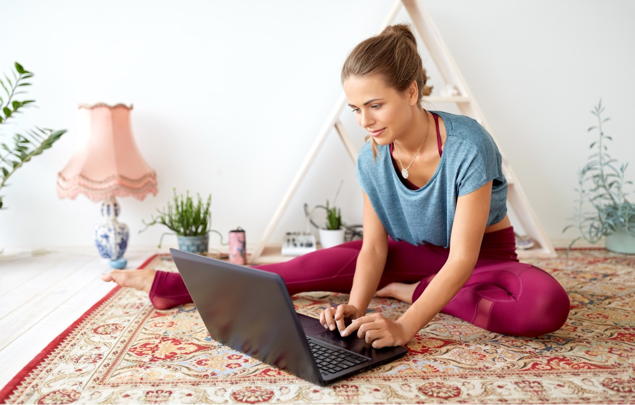 Yoga teacher managing her bookings on a laptop.